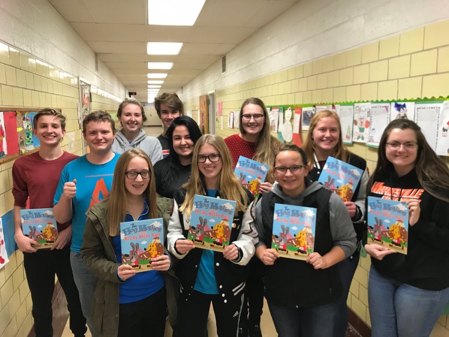 students holding up books